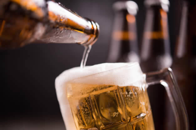 Garrafa de cerveja servindo copo