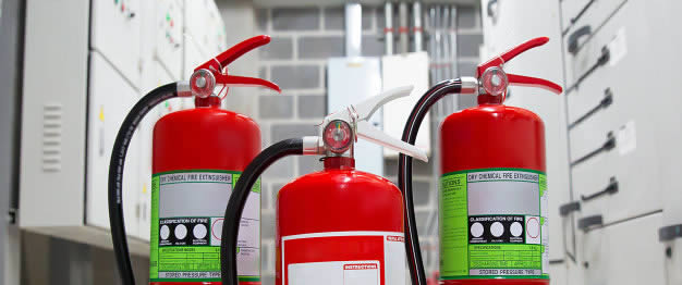 Close-up de três tipos de extintores de incêndio