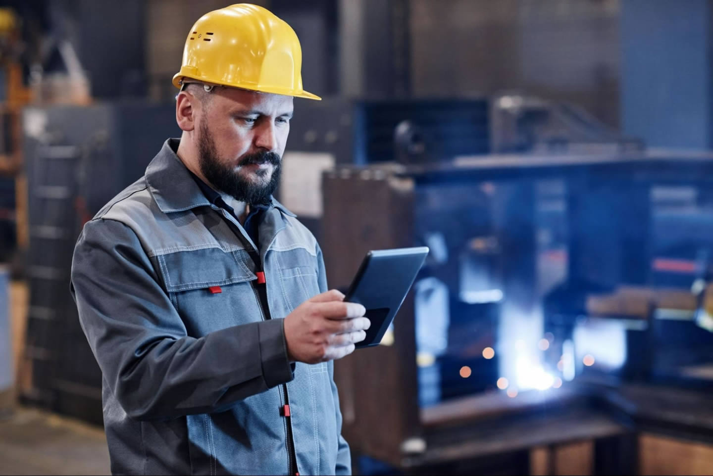 Engenheiro realizando a verificação da produção por um aparelho digital