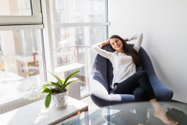 Mulher relaxando em casa aproveitando os benefícios dos íons negativos