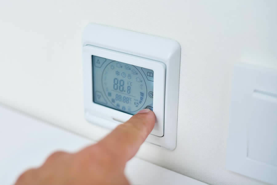 Mão ajustando temperatura adequada em painel